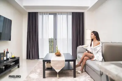 a woman sitting on a couch in a living room at Luxury Hotel near City of Dreams, Solaire, NAIA, and MOA - City of Bridge in Manila