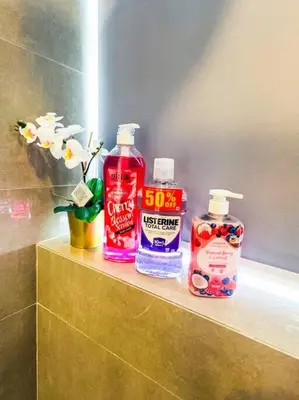 three bottles of detergent sitting on a shelf in a bathroom at Luxury Hotel near City of Dreams, Solaire, NAIA, and MOA - City of Bridge in Manila