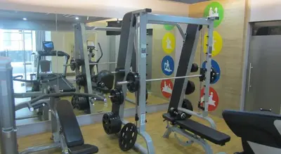 a gym with several tread machines in a room at Newport City Condos in Manila