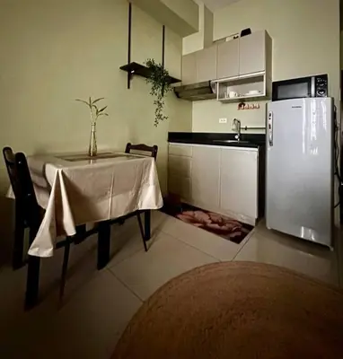 a kitchen with a table and a refrigerator at Tropical Haven in Makati CBD in Manila