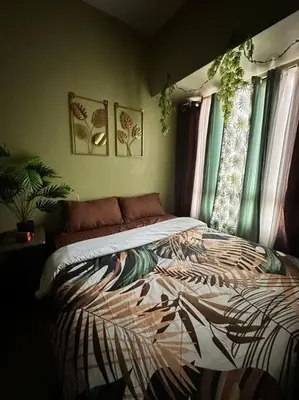 a bedroom with a bed in a room with windows at Tropical Haven in Makati CBD in Manila