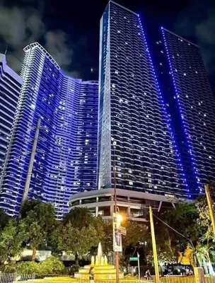 a large building with blue lights on it at Air Residences - Pool View Balcony near Airport - 4576 in Manila