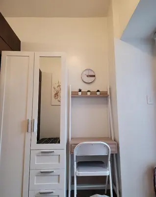 a closet with a mirror and a chair in a room at Air Residences - Balcony Pool View near Airport - 1721 in Manila