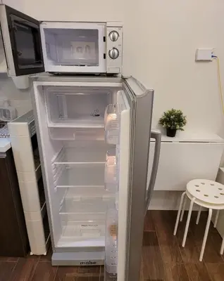 a refrigerator with a microwave on top of it at Air Residences - Balcony Pool View near Airport - 1721 in Manila