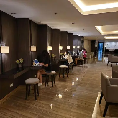 a lobby of a hotel with people sitting at tables at Air Residences - High Floor City View near Airport - 5759 in Manila