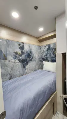 a bed in a room with a marble wall at SMDC Coast Residences in Manila