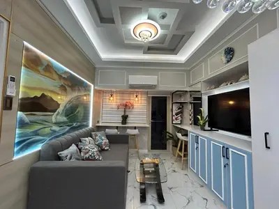 a living room with a couch and a tv at SMDC Coast Residences in Manila