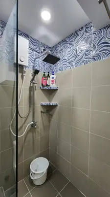 a bathroom with a shower and a toilet in it at SMDC Coast Residences in Manila