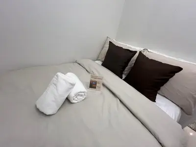 a white bed with a book and towels on it at Shore 2 Tower 3 in Manila