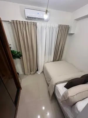 a small room with two beds and a window at Shore 2 Tower 3 in Manila