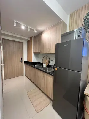 a kitchen with a black refrigerator and a sink at Shore 2 Tower 3 in Manila