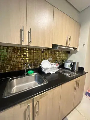 a kitchen with a sink and a counter top at Lanz staycation breeze residences in Manila