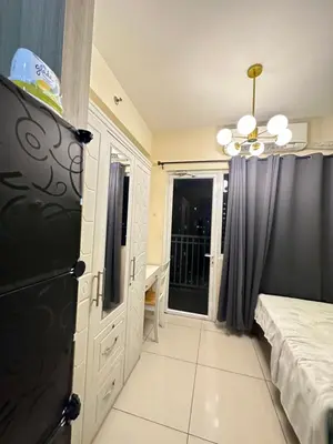 a room with a bed and a black refrigerator at Lanz staycation breeze residences in Manila