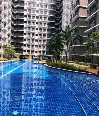 a large swimming pool in front of a large building at Shore2 staycation in Manila