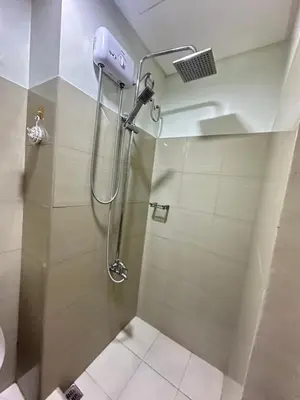 a shower with a shower head in a bathroom at Shore2 staycation in Manila