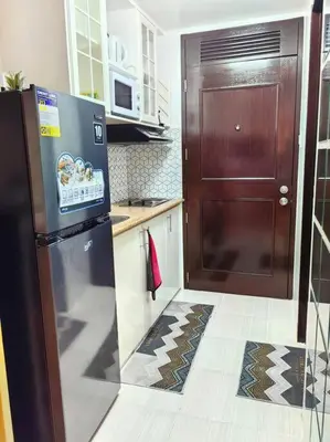 a kitchen with a refrigerator and a wooden door at Condotel Near Airport Terminals in Manila