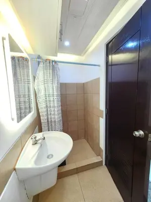 a bathroom with a toilet and a sink and a shower at Condotel Near Airport Terminals in Manila
