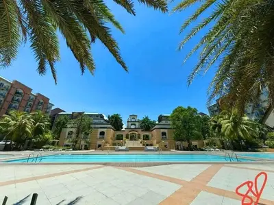a building with a swimming pool in a courtyard with trees at Condotel Near Airport Terminals in Manila