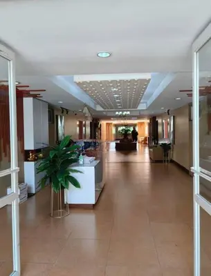 a hallway in a building with a plant in the middle at Condotel Near Airport Terminals in Manila