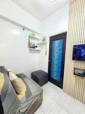 a bedroom with a bed and a door with a window at Condotel Near Airport Terminals in Manila