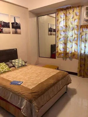 a bedroom with a large bed and a window at Ivy Condotels Unit -101Newport Boulevard in Manila