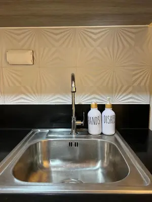 a kitchen sink with two mugs on top of it at Twin Duckworth Suites T3 in Manila