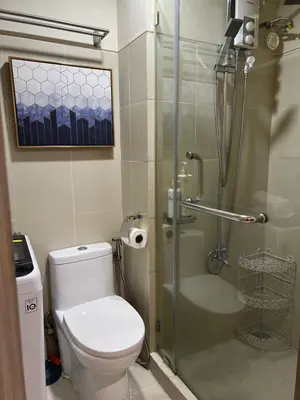 a bathroom with a toilet and a glass shower at Twin Duckworth Suites T3 in Manila