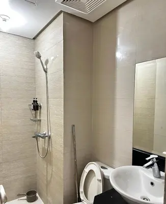 a bathroom with a shower and a toilet and a sink at Tranquil Space Across Airport NAIA 3 in Manila