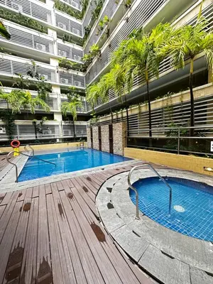 an indoor pool in a building with palm trees at Tranquil Space Across Airport NAIA 3 in Manila