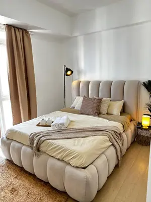 a large bed with a large tufted headboard in a bedroom at Tranquil Space Across Airport NAIA 3 in Manila