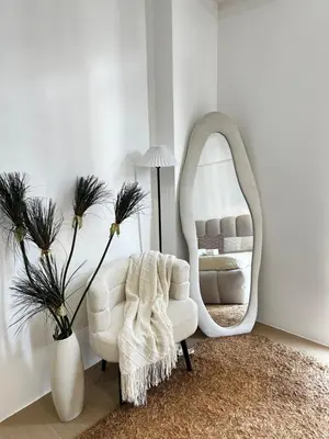 a living room with a white chair and a mirror at Tranquil Space Across Airport NAIA 3 in Manila