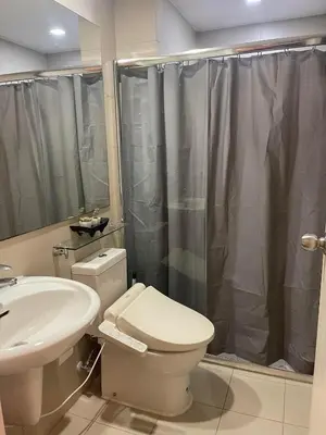 a bathroom with a toilet and a sink and a shower at KYH STAYCATION 2BR by Azure Residences Near Airport in Manila