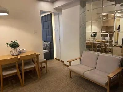 a living room with a table and chairs and a dining room at KYH STAYCATION 2BR by Azure Residences Near Airport in Manila