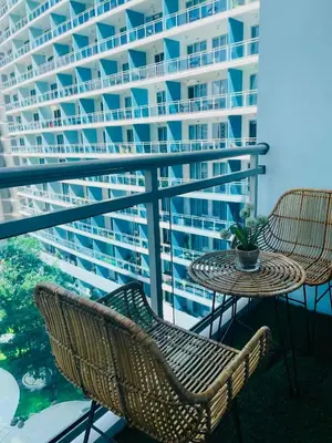 a balcony with a table and chairs and a large building at KYH STAYCATION 2BR by Azure Residences Near Airport in Manila