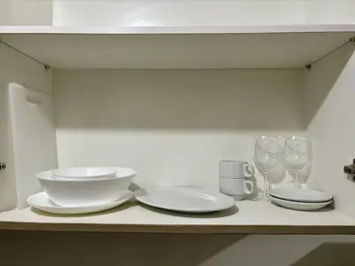 a table with two plates and wine glasses on it at New Oasis Staycation Shore 2 in Manila