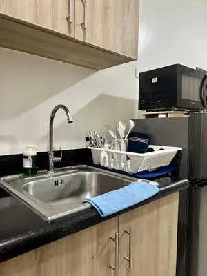 a kitchen counter with a sink and a microwave at New Oasis Staycation Shore 2 in Manila