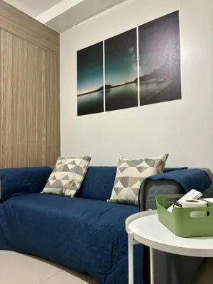 a living room with a blue couch and a table at New Oasis Staycation Shore 2 in Manila