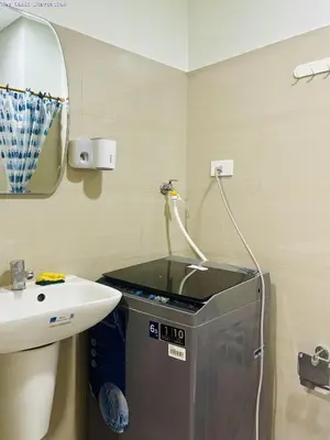 a bathroom with a sink and a washing machine at New Oasis Staycation Shore 2 in Manila