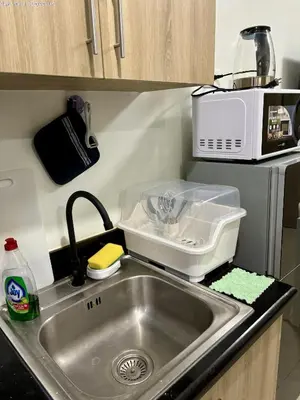 a kitchen counter with a sink and a microwave at New Oasis Staycation Shore 2 in Manila