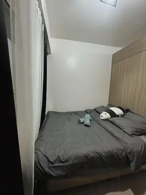 a bed with a stuffed animal on it in a bedroom at 1BR Shore Residences near Mall Of Asia in Manila
