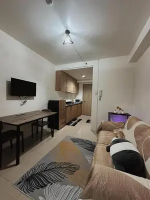 a living room with a couch and a dining room table at 1BR Shore Residences near Mall Of Asia in Manila