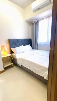 a bedroom with a bed and a window at Stunning Suite with Balcony near MOA in Manila