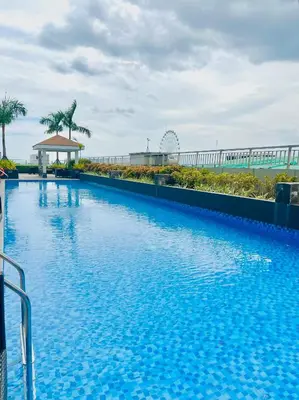 a large blue swimming pool on the side of a building at Stunning Suite with Balcony near MOA in Manila
