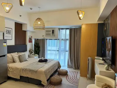 a bedroom with a bed and a tv in a room at Studio Unit McKinley Hill Taguig cd21H in Manila