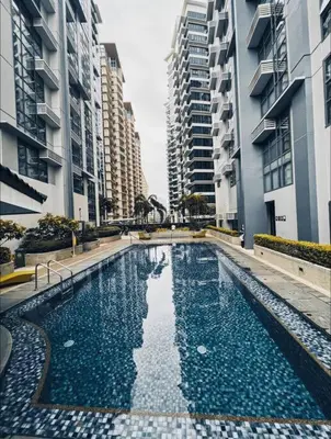 a swimming pool in the middle of two tall buildings at Studio Unit McKinley Hill Taguig cd21H in Manila