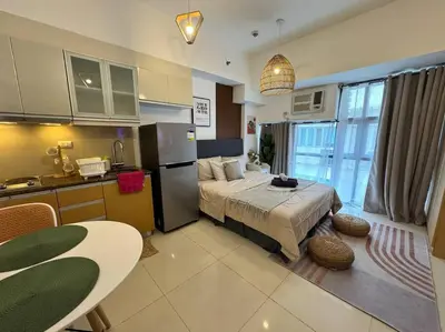 a bedroom with a bed and a kitchen with a table at Studio Unit McKinley Hill Taguig cd21H in Manila