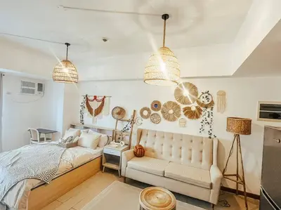 a bedroom with a bed and a couch and pendant lights at Venice Luxury Residences Studio McKinley Hill in Manila