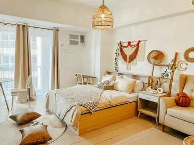 a bedroom with a bed and a couch and a chair at Venice Luxury Residences Studio McKinley Hill in Manila