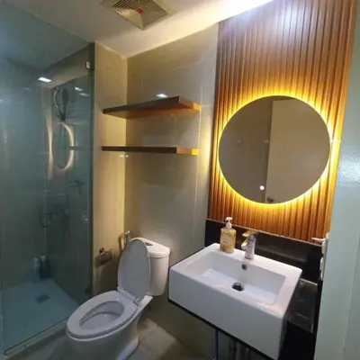 a bathroom with a toilet and a sink and a mirror at Venice Luxury Residences Studio McKinley Hill in Manila