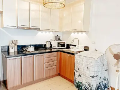 a kitchen with white cabinets and a microwave at Venice Luxury Residences Studio McKinley Hill in Manila